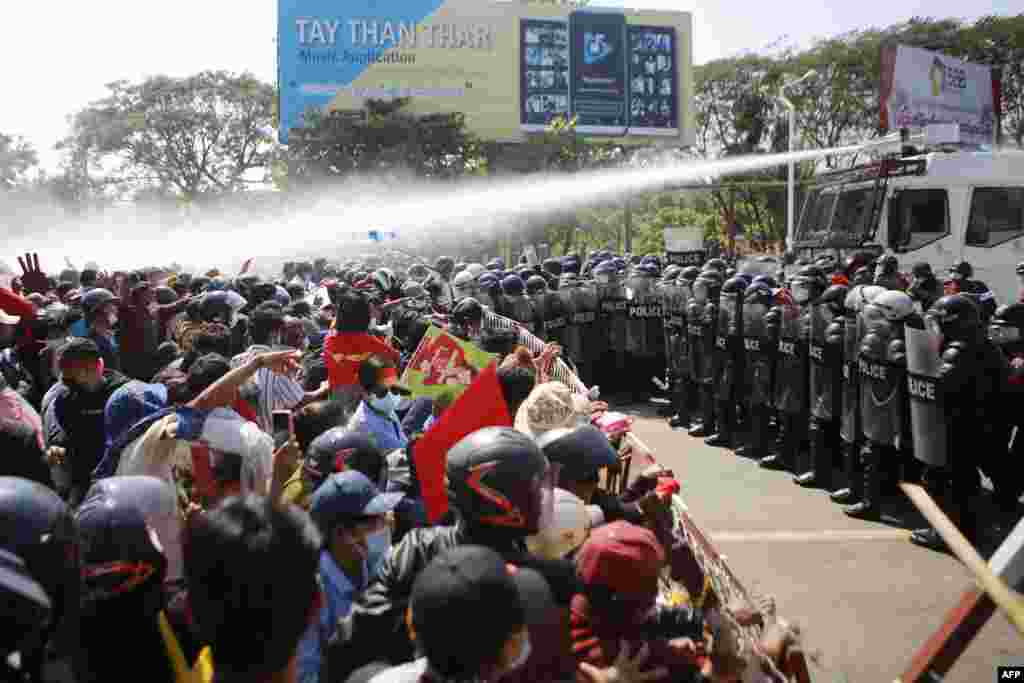 Police fire water cannons at protesters as they continue to demonstrate against the February 1 military coup in the capital Naypyidaw on February 9, 2021. (Photo by STR / AFP)