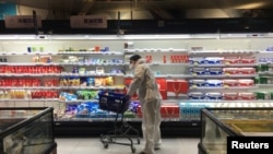 A shopper pushes a cart inside a supermarket on February 11 following an outbreak of the new coronavirus in the Chinese city of Wuhan in Hubei Province. 