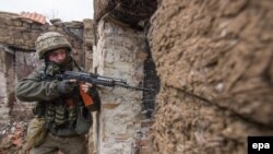 Український військовий патрулює у зруйнованому обстрілами бойовиків селі Водяне біля Маріуполя, архівне фото