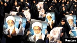 Bahraini protesters hold up posters of Shi'ite cleric Ayatollah Isa Qassem during an antigovernment demonstration in 2013.