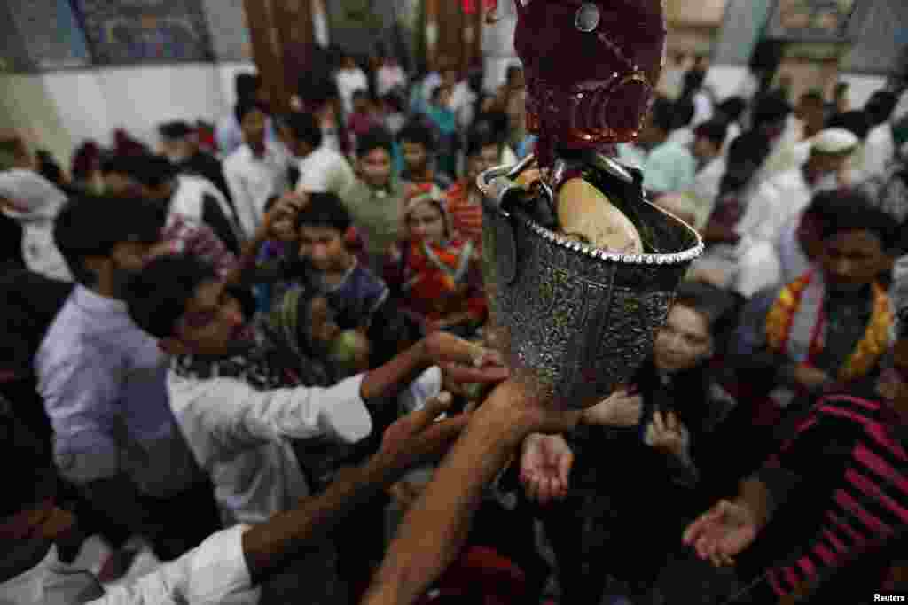 Devotees reach out for sacred water inside the shrine in 2013. Sufism draws on some rituals of pre-Islamic traditions. 