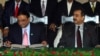Pakistani President Asif Ali Zardari (left) signing a constitutional reform law as Prime Minister Yousuf Raza Gilani (R) looks on during a ceremony in Islamabad in April 2010.