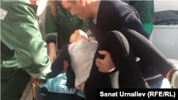 Житель Березовки Казбек Ирмикбаев помогает врачам госпитализировать свою 17-летнюю дочь Динару после повторного падения в обморок в местной школе. Уральск, 21 января 2015 года.