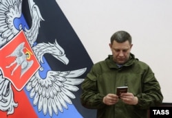 Donetsk separatist leader Aleksandr Zakharchenko holds his "passport" after receiving it during a ceremony on March 16.