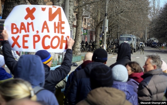 Люди стоять перед військовими Росії під час мітингу проти російської окупації. Херсон, 14 березня 2022 року