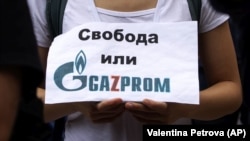Демонстрант држи плакат на кој пишува „Слобода или Газпром“ за време на протестниот митинг во центарот на Софија пред зградата на бугарското претседателство. 10 август 2022 година