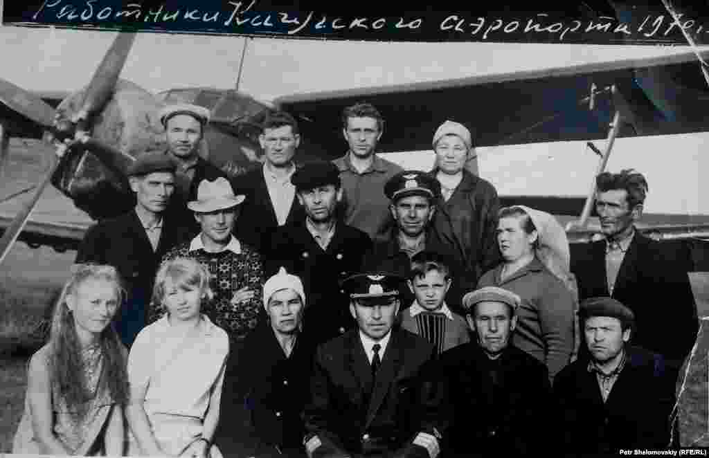 Vladimir (center front) with airfield staff in his piloting days. In the background is one of the Soviet AN-2 biplanes that serviced Prokopyev&#39;s airport. He finished his career flying the Tupolev TU-104, one of the world&#39;s first passenger jets.