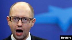 Ukrainian Prime Minister Arseniy Yatsenyuk talks to reporters after leaving a European Union leaders summit in Brussels on March 21.