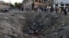 Afghan security forces and residents stand near the crater left by a deadly truck-bomb attack in Kabul on May 31.