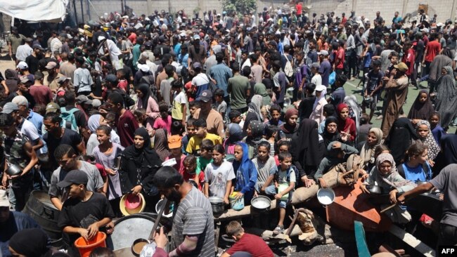 Palestinieni la un punct de distribuire a ajutoarelor, la tabăra de refugiați Nuseirat, din centrul Fâșiei Gaza, pe 19 iulie 2025.