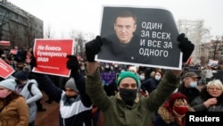 A participant holds a placard reading "One for all, all for one" during a rally in support of jailed Russian opposition leader Aleksei Navalny in Moscow on January 23.