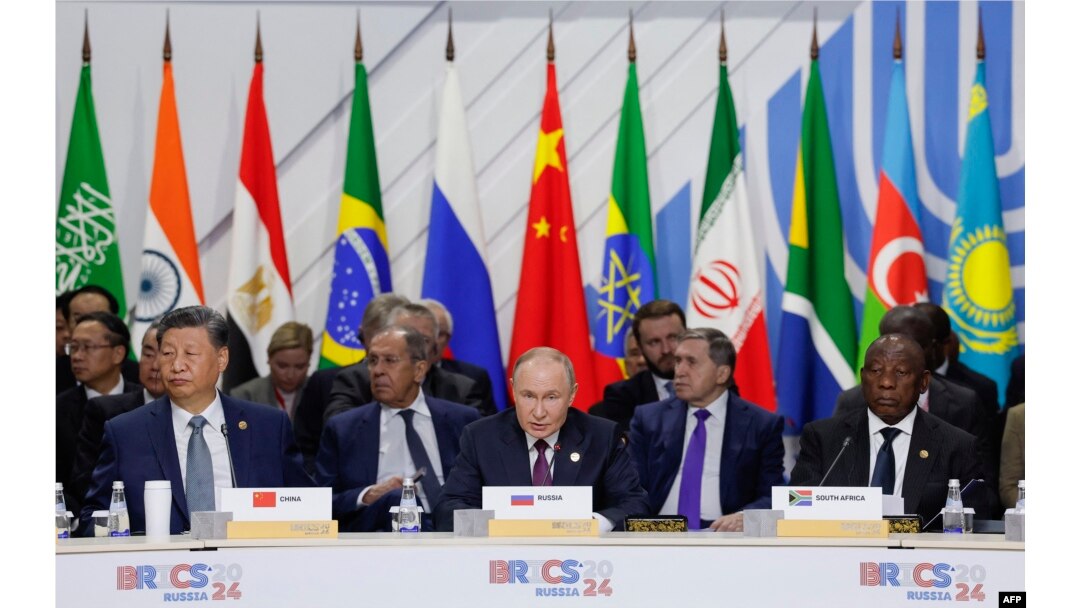 Sesiune a BRICS: Vladimir Putin stă între liderul chinez Xi Jinping și președintele sud-african Cyril Ramaphosa. În spatele său stă ministrul de Externe Serghei Lavrov. Kazan, 24 octombrie.