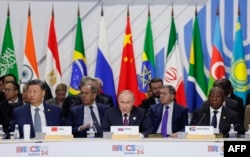 Sesiune a BRICS: Vladimir Putin stă între liderul chinez Xi Jinping și președintele sud-african Cyril Ramaphosa. În spatele său stă ministrul de Externe Serghei Lavrov. Kazan, 24 octombrie.