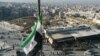 SYRIA - A Syrian opposition flag flies above a market square in central Aleppo captured by Jihadists and their Turkish-backed allies, November 30, 2024. 