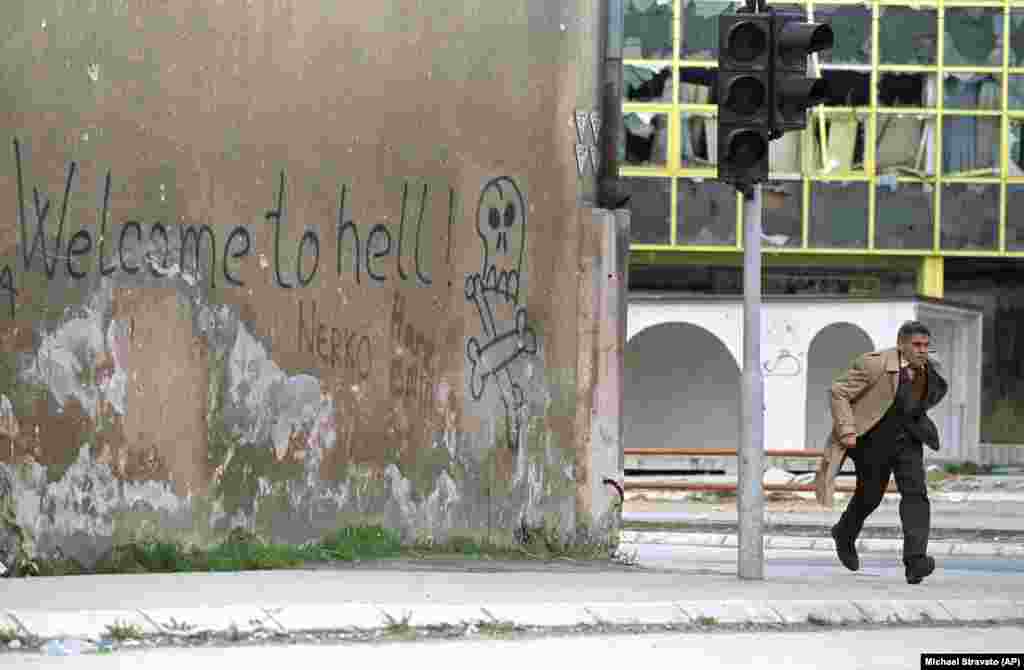 A Bosnian man runs across a street in Sarajevo that was frequently raked by sniper fire, in 1993. More than 5,000 civilians were killed during the nearly four years the city was besieged by Bosnian Serb forces who held the hills surrounding Sarajevo.