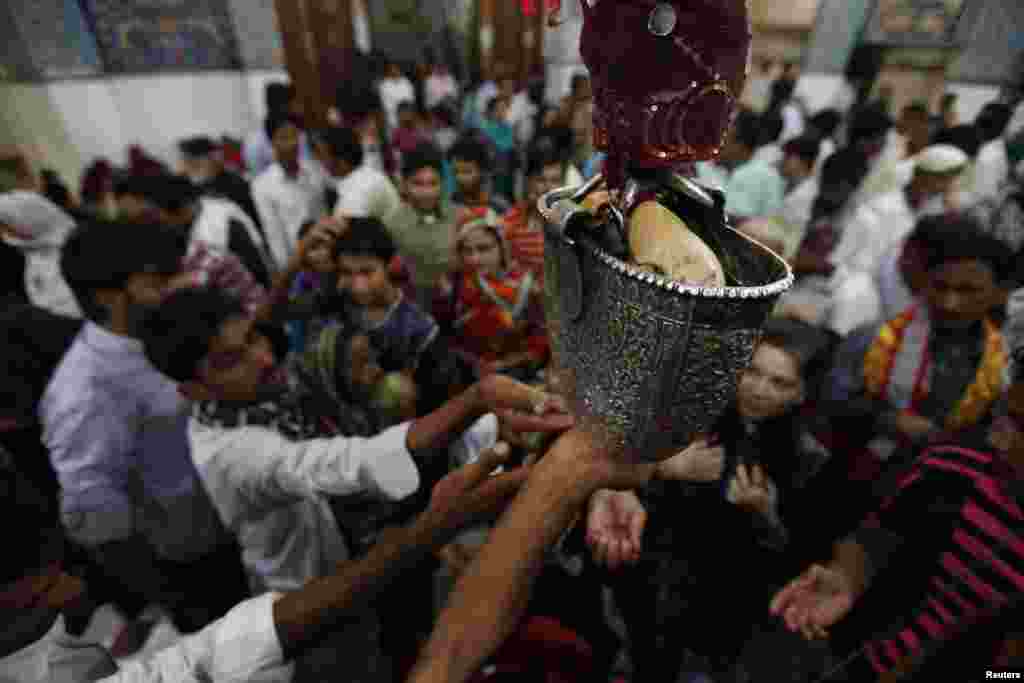 Devotees reach out for sacred water inside the shrine in 2013. Sufism draws on some rituals of pre-Islamic traditions.&nbsp;