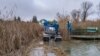 Az Országos Vízügyi Főigazgatóság munkatársai speciális gépekkel tisztítják Szigetszentmiklós közelében a Ráckevei-Soroksári Duna-ágnál a vizet és az olajszennyezéstől.
