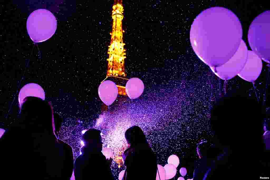 People hold balloons to release them at the turn of the New Year at a hotel in front of the landmark Tokyo Tower in Tokyo, Japan, on December 31. (Reuters/Thomas Peter)