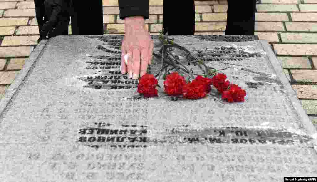 A veteran lays flowers at a monument in memory of those who died in the Soviet war in Afghanistan during a commemoration ceremony in Kyiv on February 15. (AFP/Sergei Supinsky)