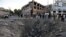 Afghan security forces and residents stand near the crater left by a truck bomb attack in Kabul on May 31.