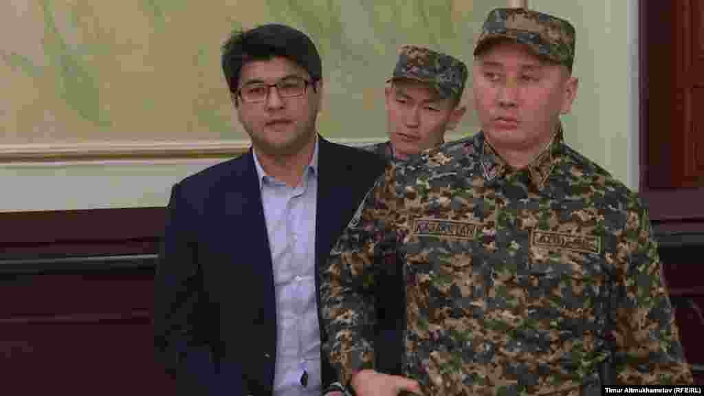 Қазақстан Ұлттық экономика министрі болған Қуандық Бишімбаев сот шешімімен он жылға сотталды. Ол "мемлекет қаржысын жымқырды, пара алды" деп айыпталды. 14 наурыз 2018 жыл. Азаттық тілшісі Тимур Айтмұханбетовтің суреті. 