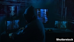 GENERIC – Internet crime concept. Hacker working on a code on dark digital background with digital interface around.