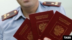 Сотрудник полиции держит в руках российские паспорта. Калининград, 23 сентября 2005 года