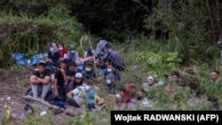 Grup de migranți, se pare din Afganistan, în apropiere de orașul polonez Byalostok, din nord-estul Poloniei, la granița cu Belarus, 20 auggust 2021.
