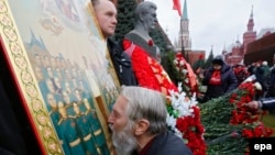 Відзначення дня народження Йосипа Сталіна на його могилі біля Кремлівської стіни на Червоній площі. Чоловік цілує ікону із зображенням радянського диктатора. Москва, 21 грудня 2015 року