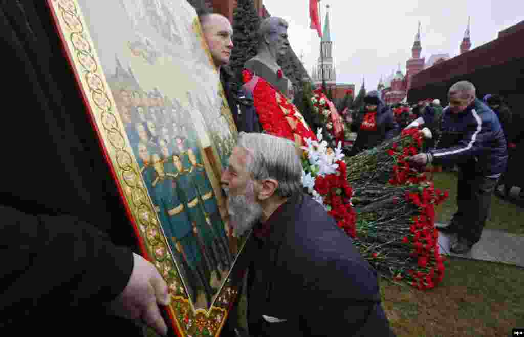 Відзначення дня народження Йосипа Сталіна на його могилі біля Кремлівської стіни на Червоній площі у столиці Росії. Чоловік цілує ікону із зображенням радянського диктатора. Москва, 21 грудня 2015 року​