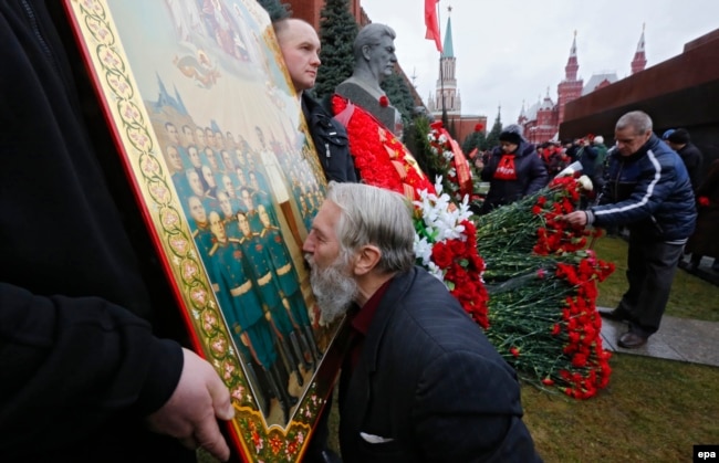 Відзначення дня народження Йосипа Сталіна на його могилі біля Кремлівської стіни на Червоній площі. Чоловік цілує ікону із зображенням радянського диктатора. Москва, 21 грудня 2015 року