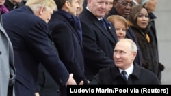 АҚШ президенті Дональд Трамп пен Владимир Путин Париждегі екінші дүниежүзілік соғыс құрбандарын еске алу рәсімінде қол алысып тұр