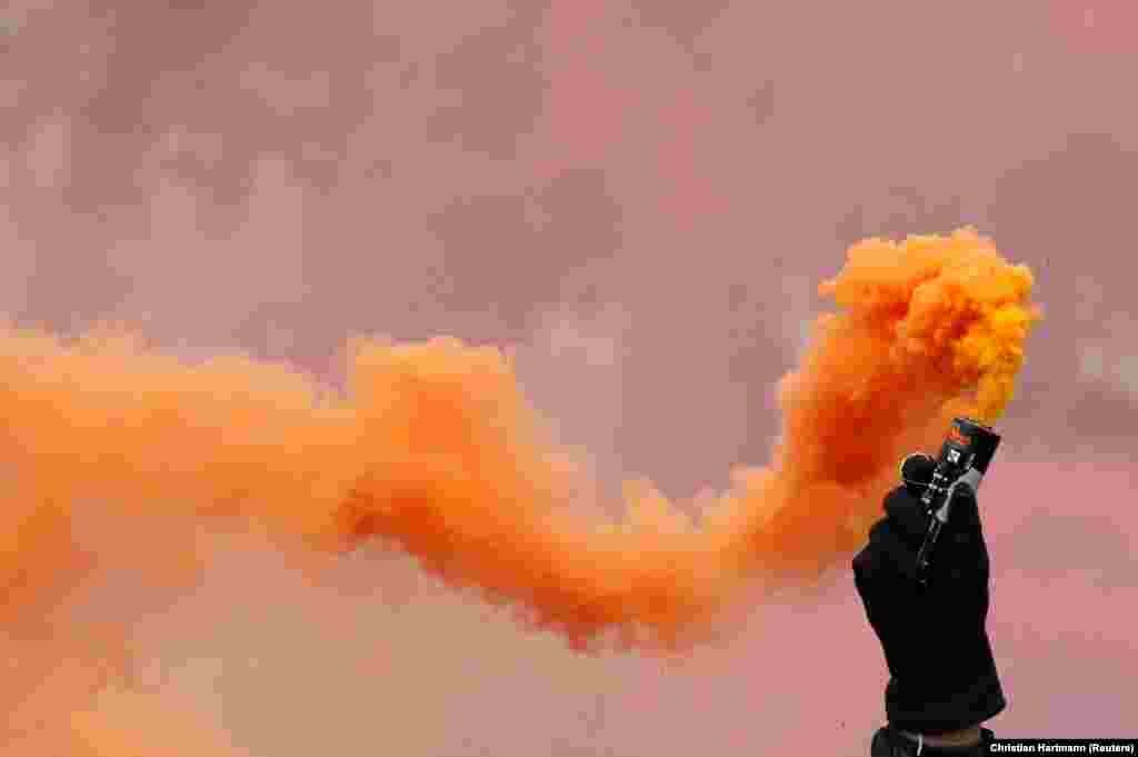 A protester holds a flare during a May Day union march in Paris, France, on May 1. (Reuters/Christian Hartmann)