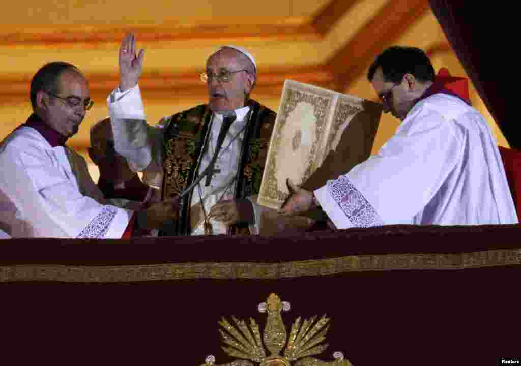 Newly elected Pope Francis (center), Cardinal Jorge Mario Bergoglio of Argentina, blesses people on the balcony of St. Peter&#39;s Basilica after being elected by the conclave of cardinals on March 13.