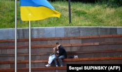 Egy fiatal pár csókolózik Kijev központjában egy parkban június 22-én