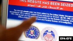 Un iranian arată pe ecran anunțul care spune că acel website a fost preluat de Statele Unite, Teheran 23 iunie 2021