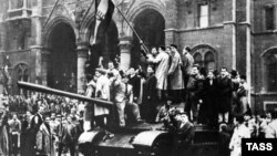 Budapestani cățărați pe un tanc sovietic în fața Parlamentului maghiar în timpul Revoluției maghiare, Budapesta 1956. 