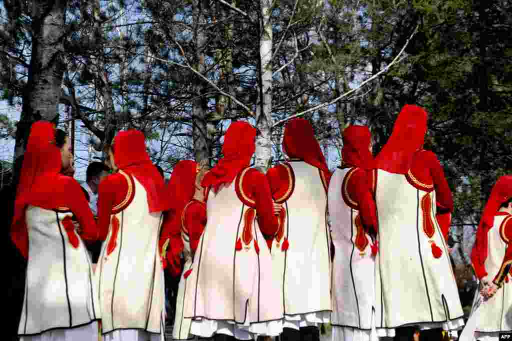 Members of a folklore group take part in a ceremony in Pristina marking 15 years since Kosovo Liberation Army commander Adem Jashari was among 45 members of his family killed by Serbian security forces in the village of Prekaz, sparking a full-blown rebel insurgency. (AFP/Armend Nimani)
