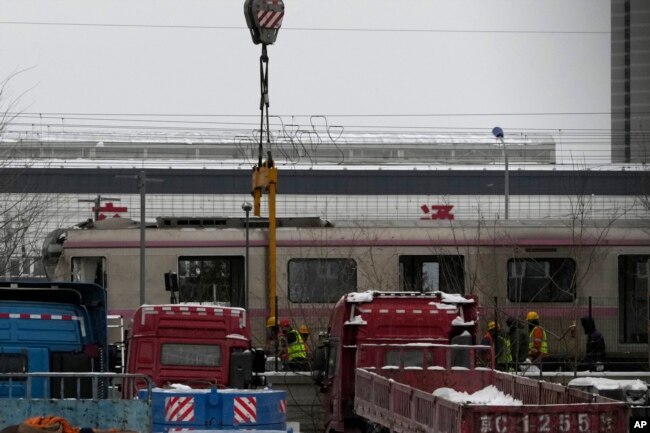 Ekipet e shpëtimit duke e larguar një vagon të trenit në vendin e aksidentit të trenave në Pekin, Kinë, 15 dhjetor 2023.