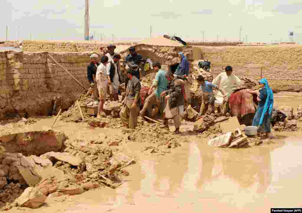 Residents of the Afghan city Mazar-e Sharif help clear debris on April 24 after heavy rains and floods washed out houses and killed a number of people.