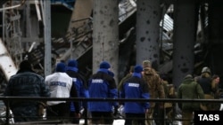 Сотрудники мониторинговой миссии ОБСЕ на территории разрушенного Донецкого аэропорта 