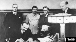 Veaceslav Molotov semnează Pactul de neagresiune cu Germania în prezența lui Stalin, la Moscova la 23 august 1939