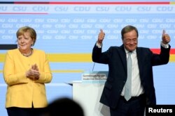 Prim-ministrul Renaniei de Nord-Westfalia și candidat pentru postul de cancelar, Armin Laschet este surprins în această fotografie alături de Angela Merkel, înaintea alegerilor federale, la Tempodrom, în Berlin, Germania, 21 august 2021.