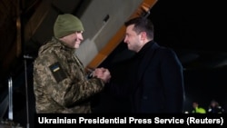 Ukrainian President Volodymyr Zelenskiy welcomes a Ukrainian serviceman who was exchanged during a prisoner swap with Russia-backed separatists at Boryspil International Airport outside Kyiv late on December 29.