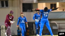 FILE: Kieran Powell (L) of West Indies caught by Afghanistan's Mohammad Nabi (C) bowled Rashid Khan Arman in a June one-day international competition.