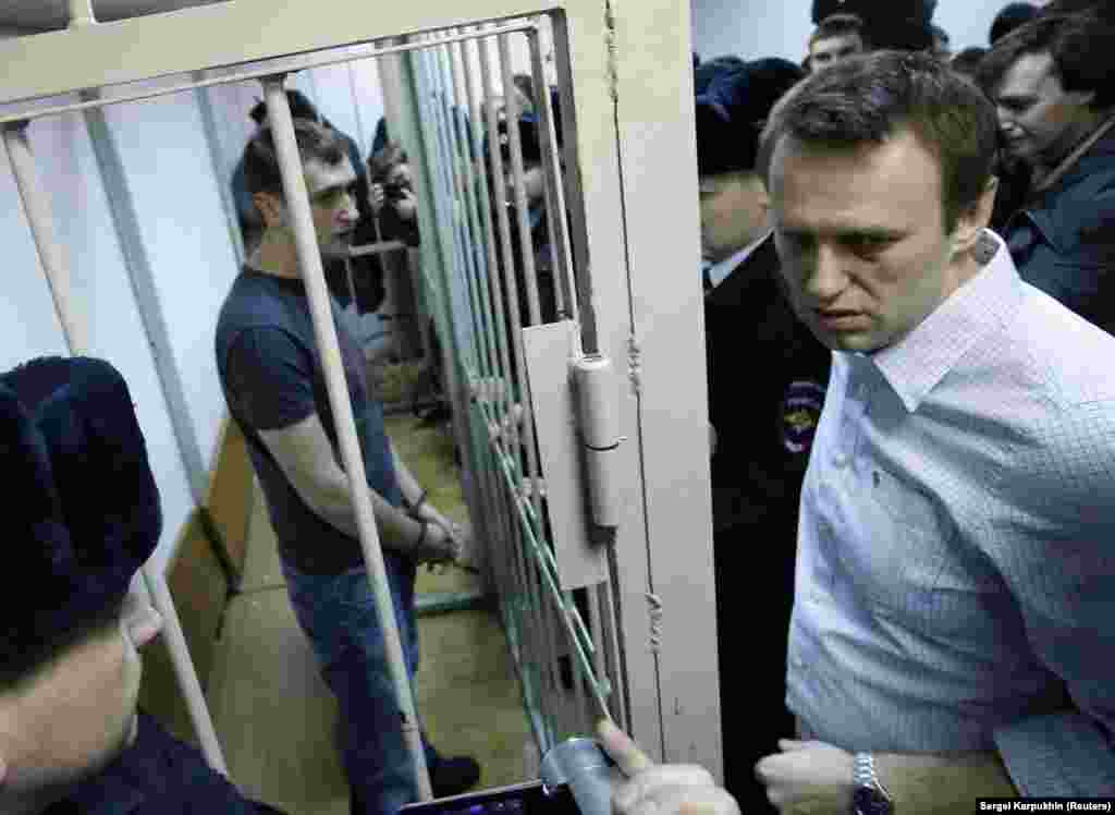 Navalny and his brother Oleg (inside cage) during a court hearing in Moscow in December 2014. The pair were convicted of stealing around $500,000 from Russian firms during business dealings dating back several years. They rejected the charges. Aleksei Navalny&rsquo;s sentence was suspended, but his brother served a full prison term of 3 1/2 years, being released in June 2018. &nbsp; &nbsp;