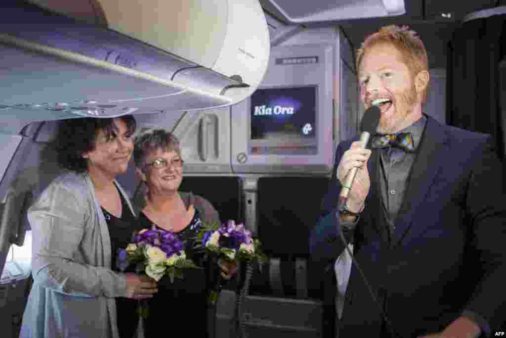 U.S. gay-rights campaigner and actor Jesse Tyler Ferguson (right) speaks in the skies above New Zealand during the same-sex marriage ceremony for Lynley Bendall (left) and Ally Wanikau on a flight from Queenstown to Auckland. New Zealand became the first Asia-Pacific country -- and only the 14th in the world -- to legalize gay marriage. (AFP)