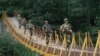 Indian Border Security Force soldiers patrol over a footbridge built over a stream near the Line of Control (file photo).