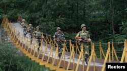 Indian border guards patrol on a footbridge built over a stream near the Line of Control (LoC), a cease-fire boundary that divides Kashmir between India and Pakistan. (file photo)