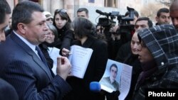 Armenia - National police chief Vladimir Gasparian (L) is confronted by protesters outside a government building in Yerevan, 12Jan2012.